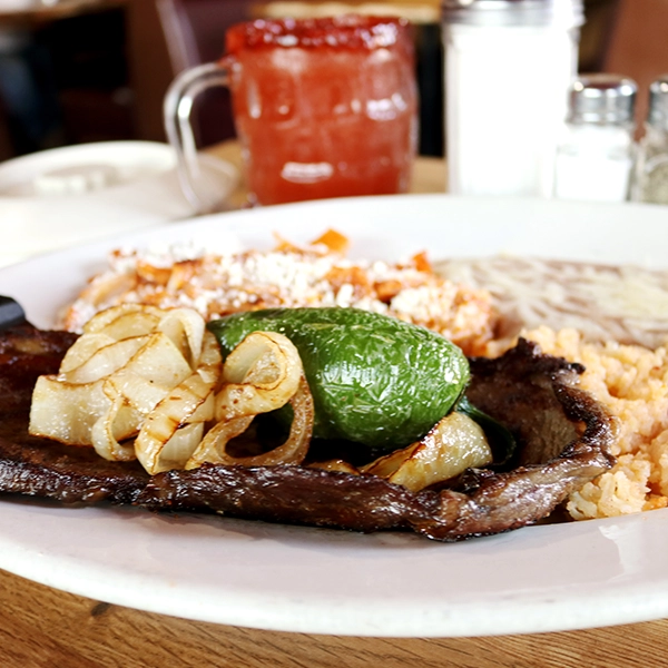 mexican style carne asada and chilaquiles with a side dish of beans and salsa