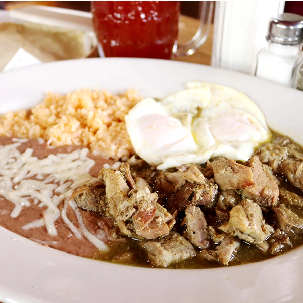 traditional home made style chile verde meat with eggs, rice and beans