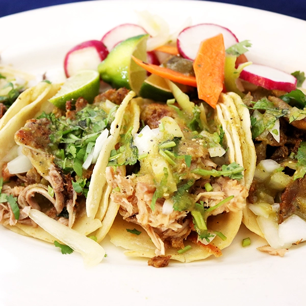 Traditional style of street tacos, meat in a corn tortilla with spicy sauce