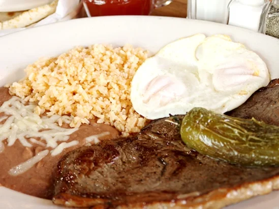 mexican style carne asada with a side egg, served with beans and rice